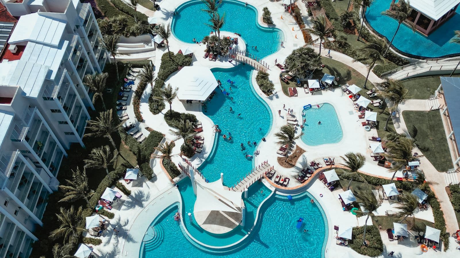 Aerial view of a tropical resort with pools and lush grounds