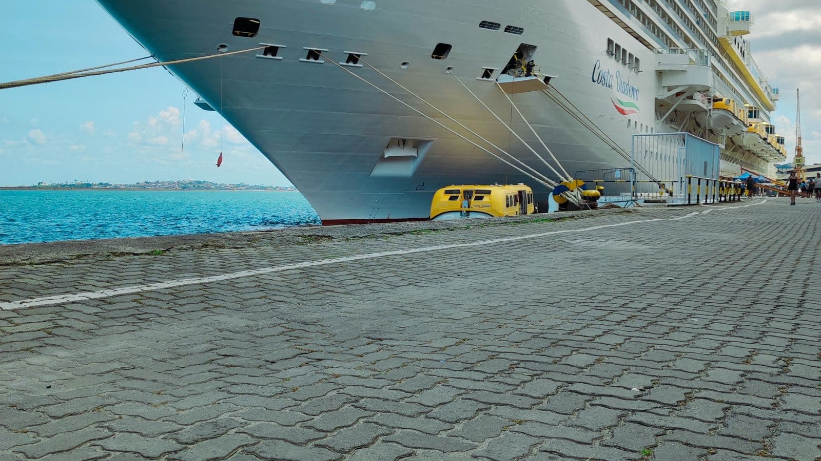 Modern cruise ship docked at a sunny port