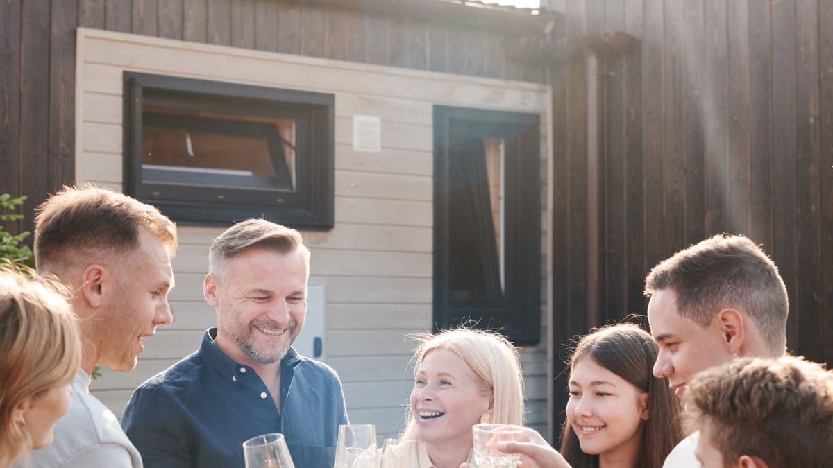 Multi-generation group raising glasses together outdoors