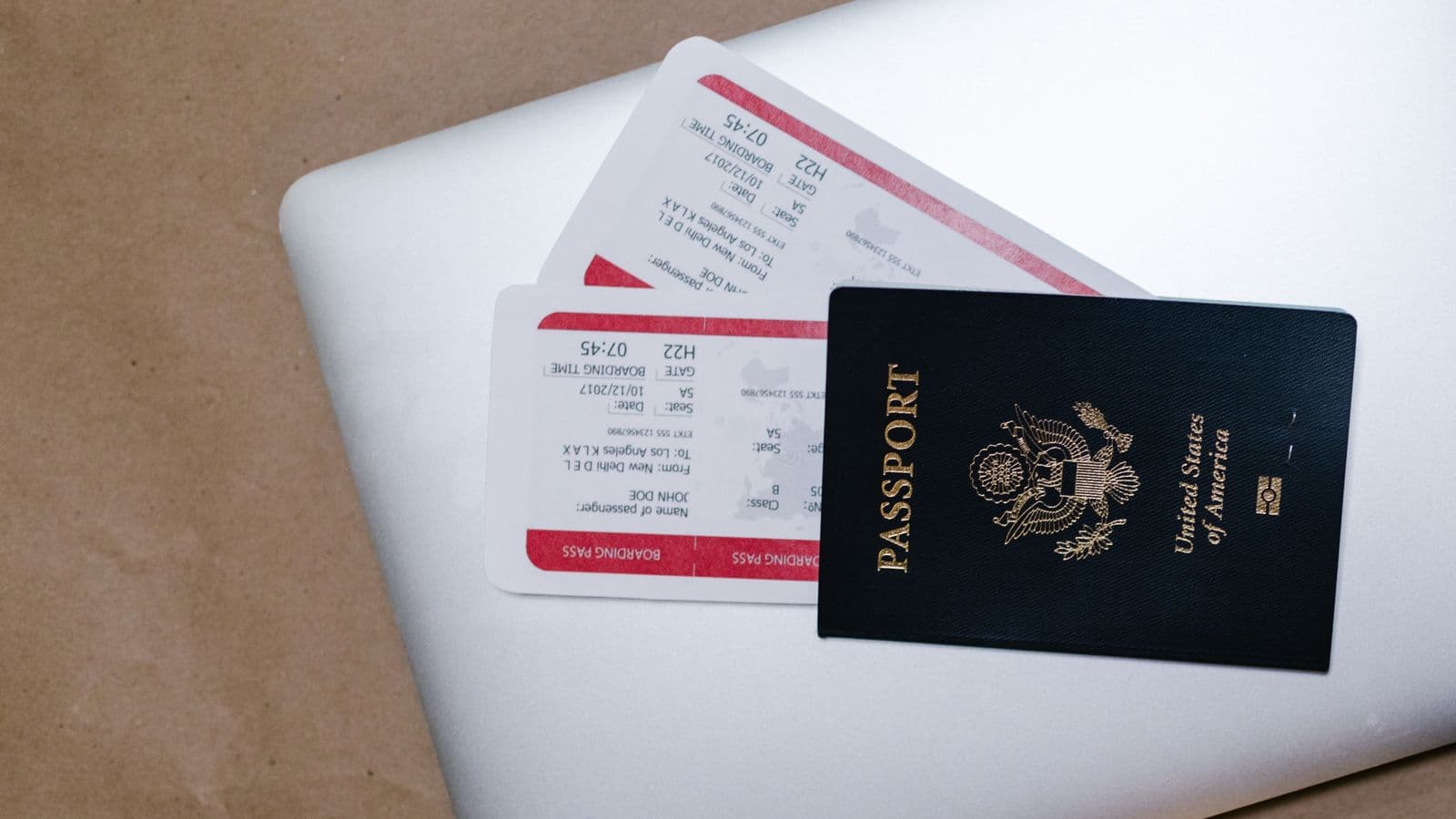 A traveler reviewing email on a laptop with a passport nearby