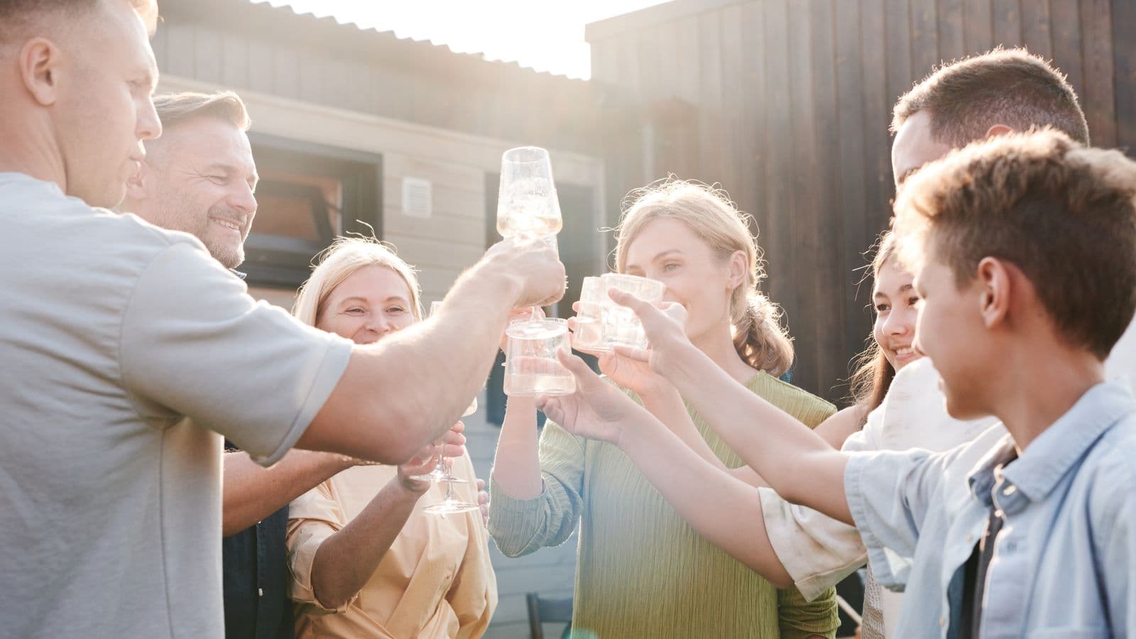 Family and friends raising glasses in a toast outdoors
