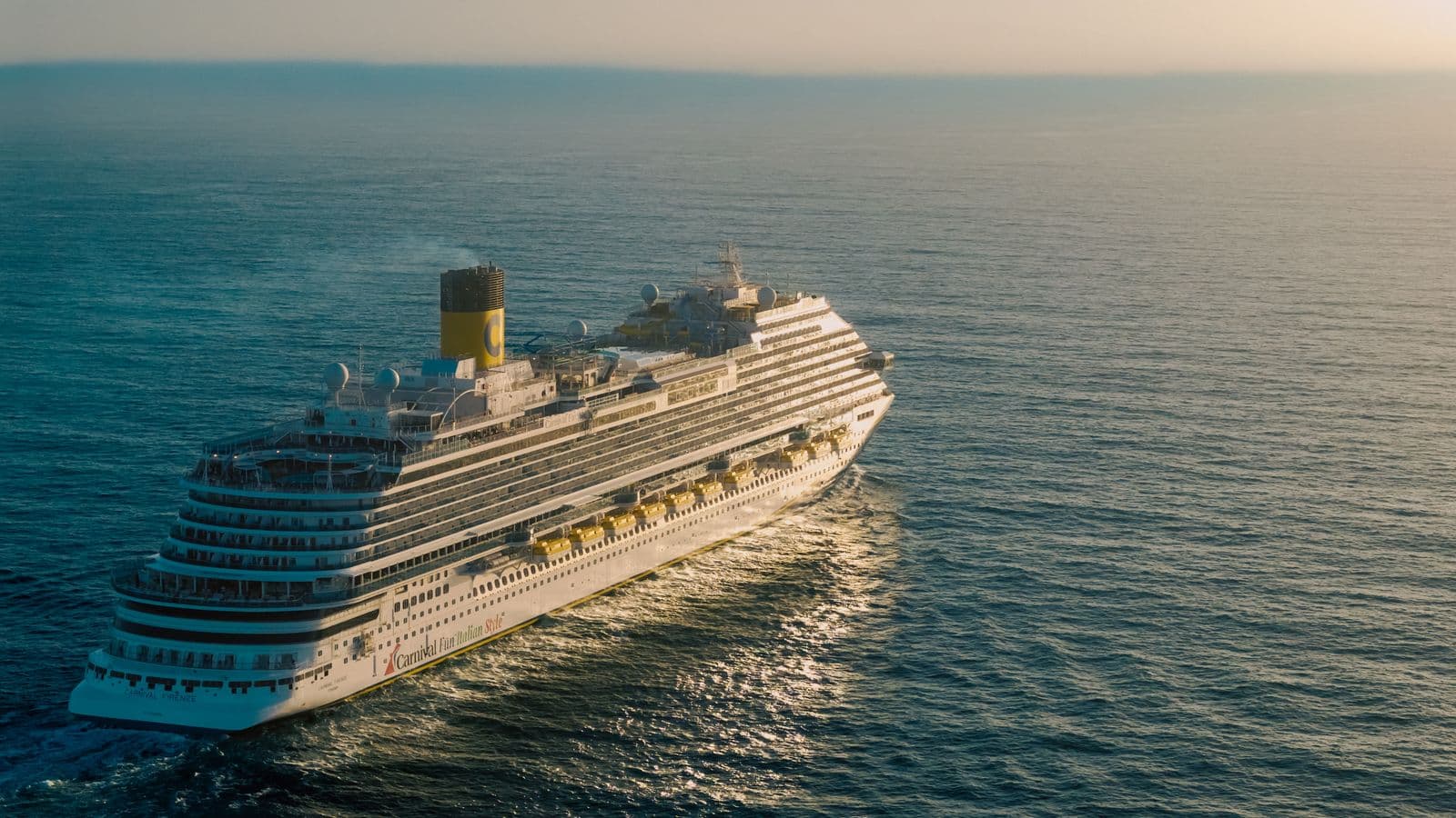 Cruise ship sailing the open ocean at sunset
