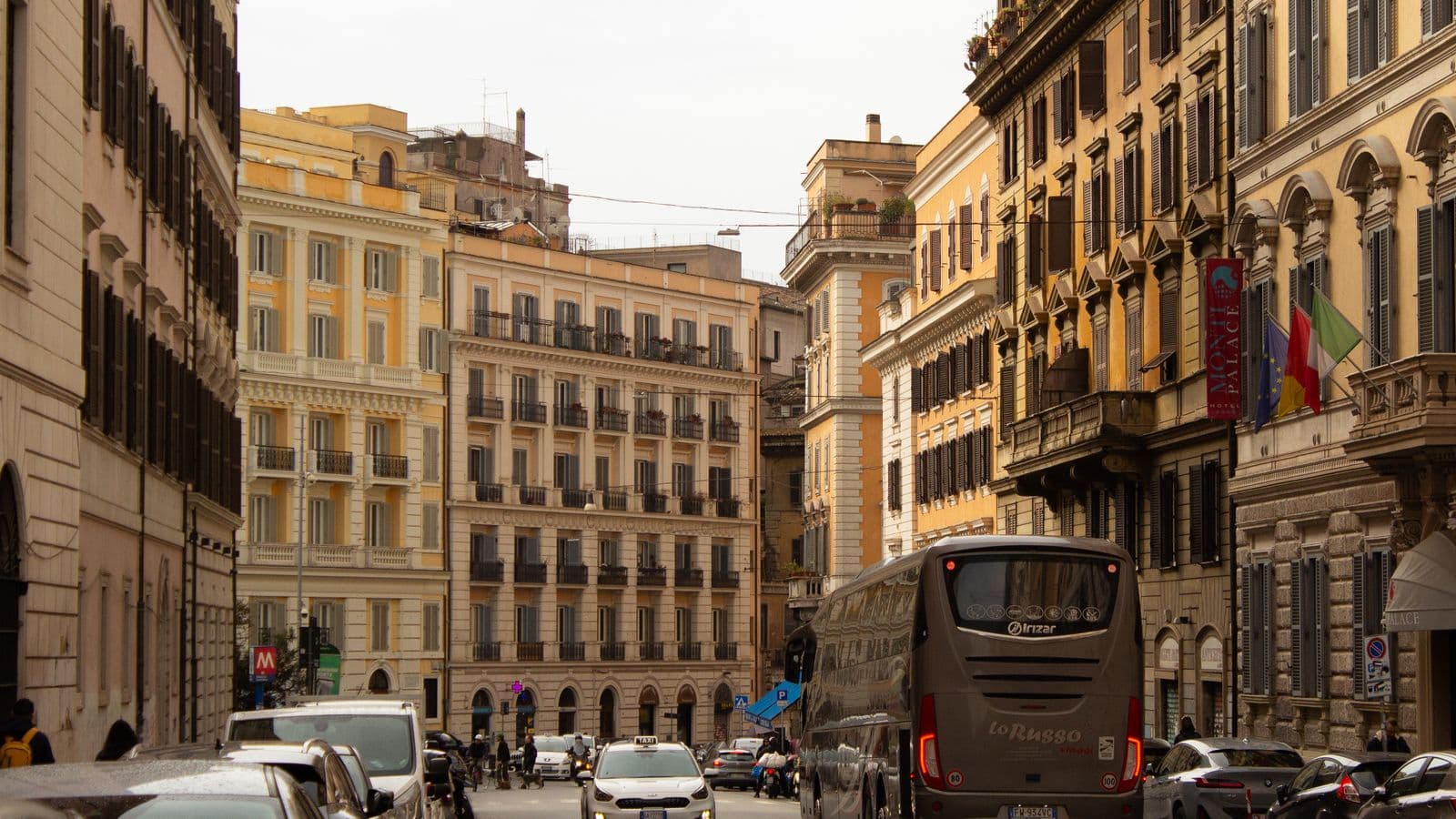 A busy European street with taxis near a historic plaza