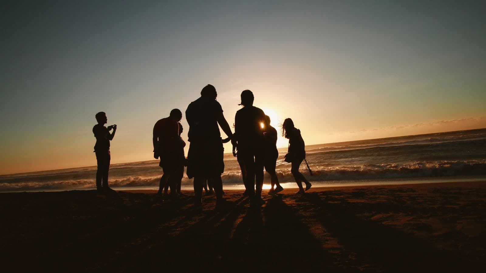 Group of friends on the beach at sunset