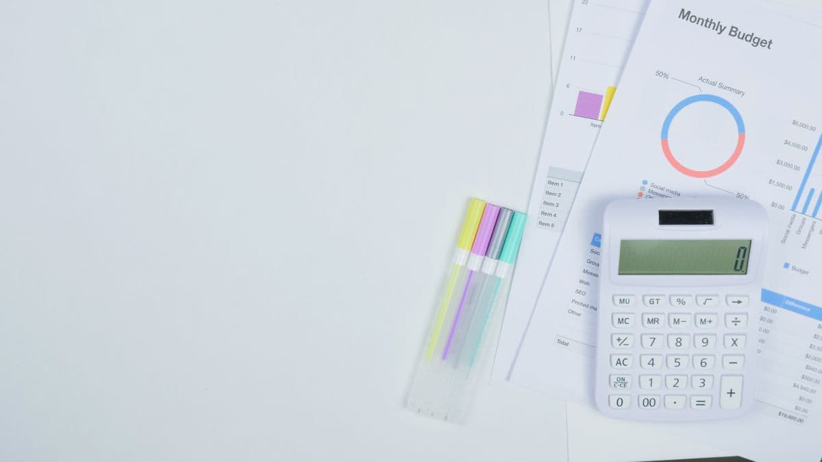 Calculator and monthly budget worksheets on a desk
